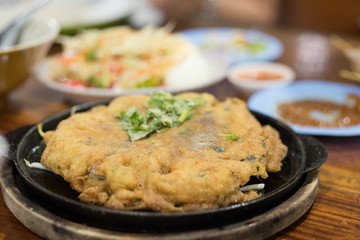 Oyster omelette or Thai-style fried mussels in a hot pan.