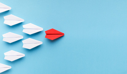 Fototapeta na wymiar One blue paper plane leading group of white ones