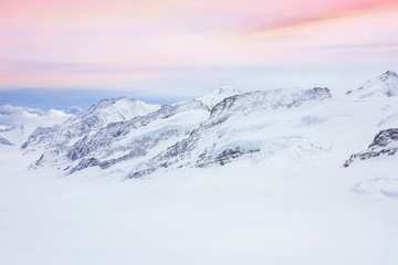 Snowy summits of mount Jungfrau in the Bernese Alps against the backdrop of sunset sky in the pastel color, Switzerland