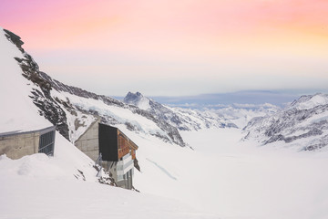 Snowy summits of mount Jungfrau in the Bernese Alps against the backdrop of sunset sky in the...