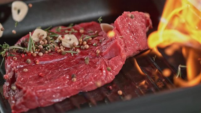 Super slowmotion footage of throwing fresh beef meat on ignited pan, 1000fps 4k
