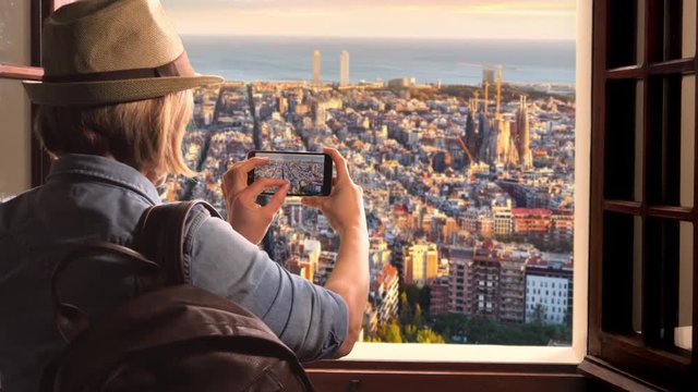 tourist  taking photograph pictures of barcelona skyline,woman takes photo of sagrada familia using smartphone
