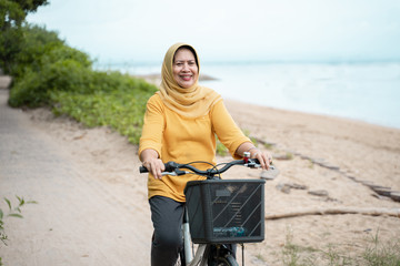 happy senior muslim female riding a bicycle
