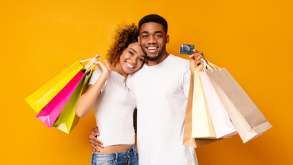 Young black couple with shopping bags and credit card