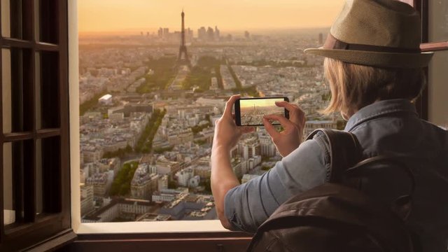 tourist taking pictures of paris skyline at sunset,woman takes photo of eiffet tower using smartphone