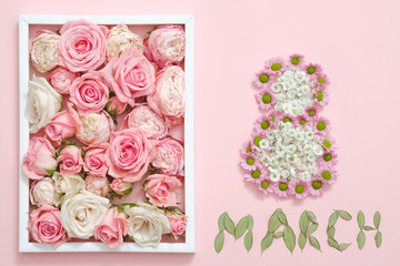 Womens day congratulation. Roses arranged in white frame. 8 march sign made of flowers. Pink background.