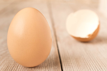 Chicken egg and eggshell on wooden table. Selective focus.