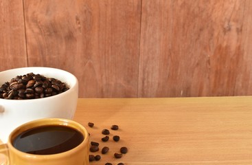 Coffee cup and coffee beans on wooden background. 