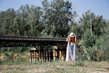 Young woman in the hat walking in the park 