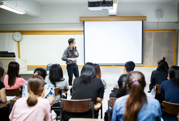 Teacher teaching studen in classroom at university.. - 245975522