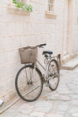 Fototapeta na wymiar old rusty vintage bicycle leaning against a stone wall