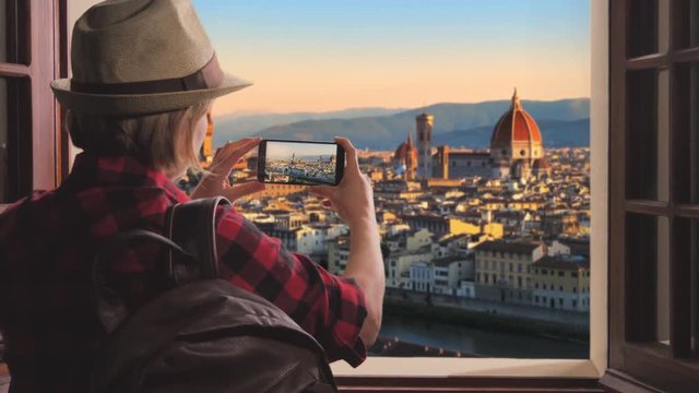 tourist taking picture of florence skyline at sunrise,woman takes photo brunelleschi dome cathedral using smartphone