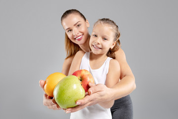 Fototapeta premium Beautiful woman and her little daughter with fresh fruits