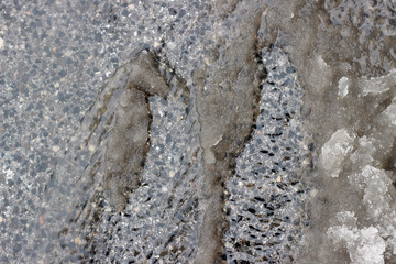 Melting snow asphalt slush water flow puddle dirty street sidewalk