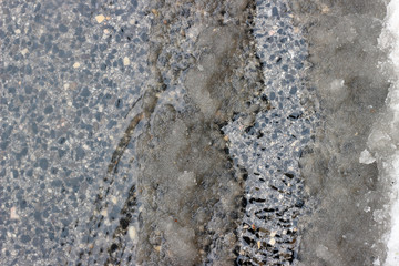 Melting snow asphalt slush water flow puddle dirty street sidewalk