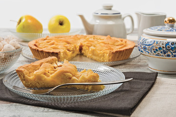 Crostata di mele tagliata con fetta con tazze per il tè e latte orizzontale