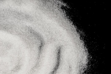 Fototapeta na wymiar Scattered sugar on a black background
