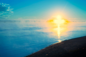 Fototapeta premium The cross of Jesus in a tranquil ocean seascape,drawn by the rays of the rising sun 