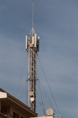 Antennenmast mit Mobilfunkantennen &uuml;ber Hausd&auml;chern