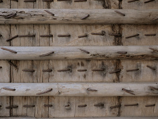 Closeup detail of rustly nails and metal structure inside old wooden door.