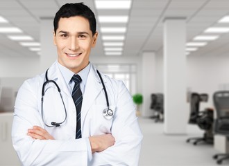 Attractive young female doctor with blurred hospital interior on