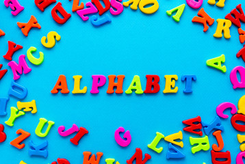 colored letters and word alphabet on blue background