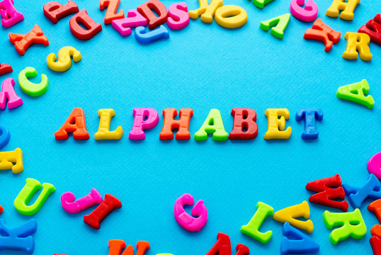 colored letters and word alphabet on blue background
