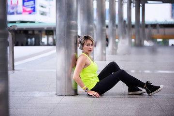 young woman in sportswear sitting in subway