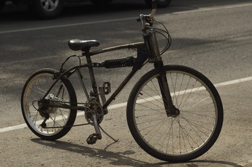 Plakat black bicycle on sunny street.