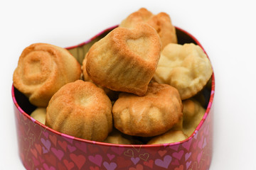 Valentine's day. Closeup of delicious cupcakes in the shape of a heart in a beautiful box in heart shape on grey background. Macro photography