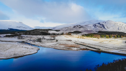 Snow covered Scottish mountains and lochs, an aerial veiw over the river Spey in Scotland