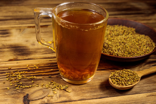 Egyptian yellow tea or Methi Dana drink and fenugreek seeds on wooden table