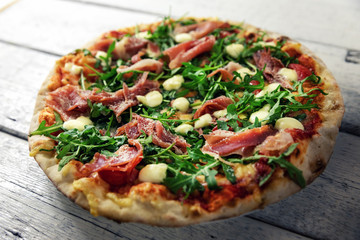 prosciutto pizza with mozzarella cheese and arugula