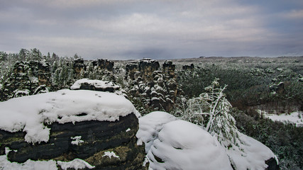 Landschaft von Felsen, Berge und Wald im Winter von der  Bastei Brücke in Elbsandsteingebirge, Nationalpark der sächsische schweiz, Deutschland