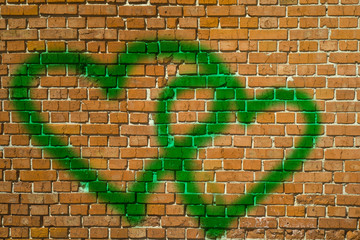 Two graffiti love red heart painted on brick wall