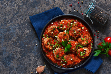 Meat balls in tomato sauce with spices concrete background. View from above.
