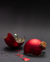 Red Christmas ball broken, dark gray background, closeup view