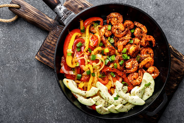 shrimp fajitas with bell pepper and onion cooked in a frying pan, top view