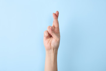 Woman showing R letter on color background, closeup. Sign language
