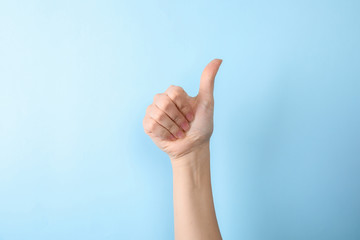 Woman showing number ten on color background, closeup. Sign language