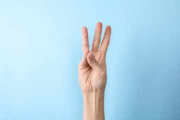 Woman showing number six on color background, closeup. Sign language