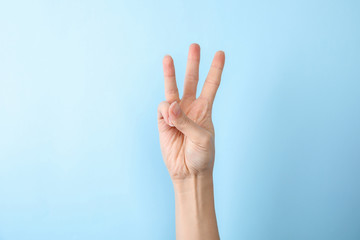 Woman showing number six on color background, closeup. Sign language