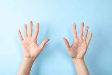 Woman showing sign ten on color background, closeup. Body language