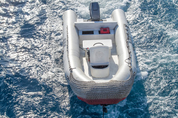 Rescue inflatable boat in the sea, towed by a yacht