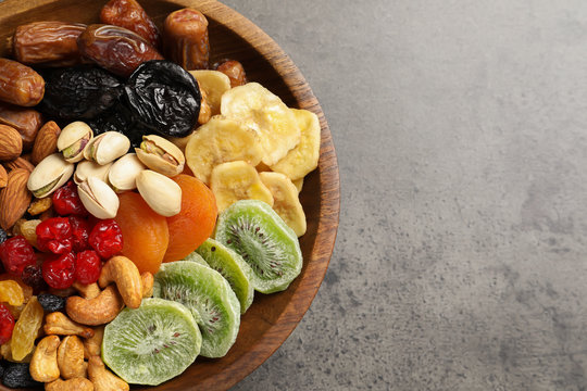Plate with different dried fruits and nuts on table, closeup. Space for text