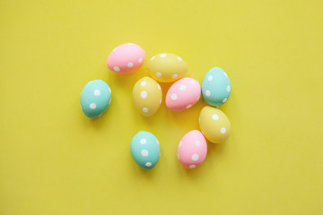 A lot of colorful Easter eggs on a yellow background. Festive Easter background.