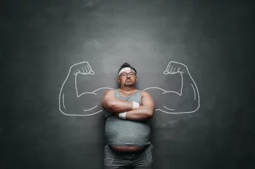  Funny sports nerd with huge muscle arms drawn on the gray background with copy space © rangizzz