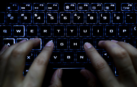 Woman working at home office hand on keyboard close up