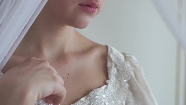 Young womans lips and shoulders in wedding dress with embroidery on white background half face real people series