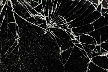 white cracked glass with dust on black background, texture